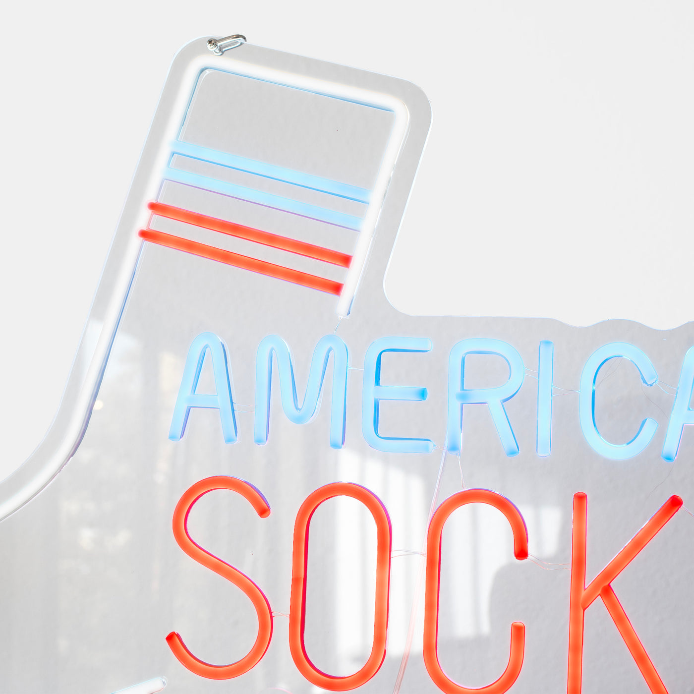 Close-up of a sock shaped neon sign partially displaying "American Socks"