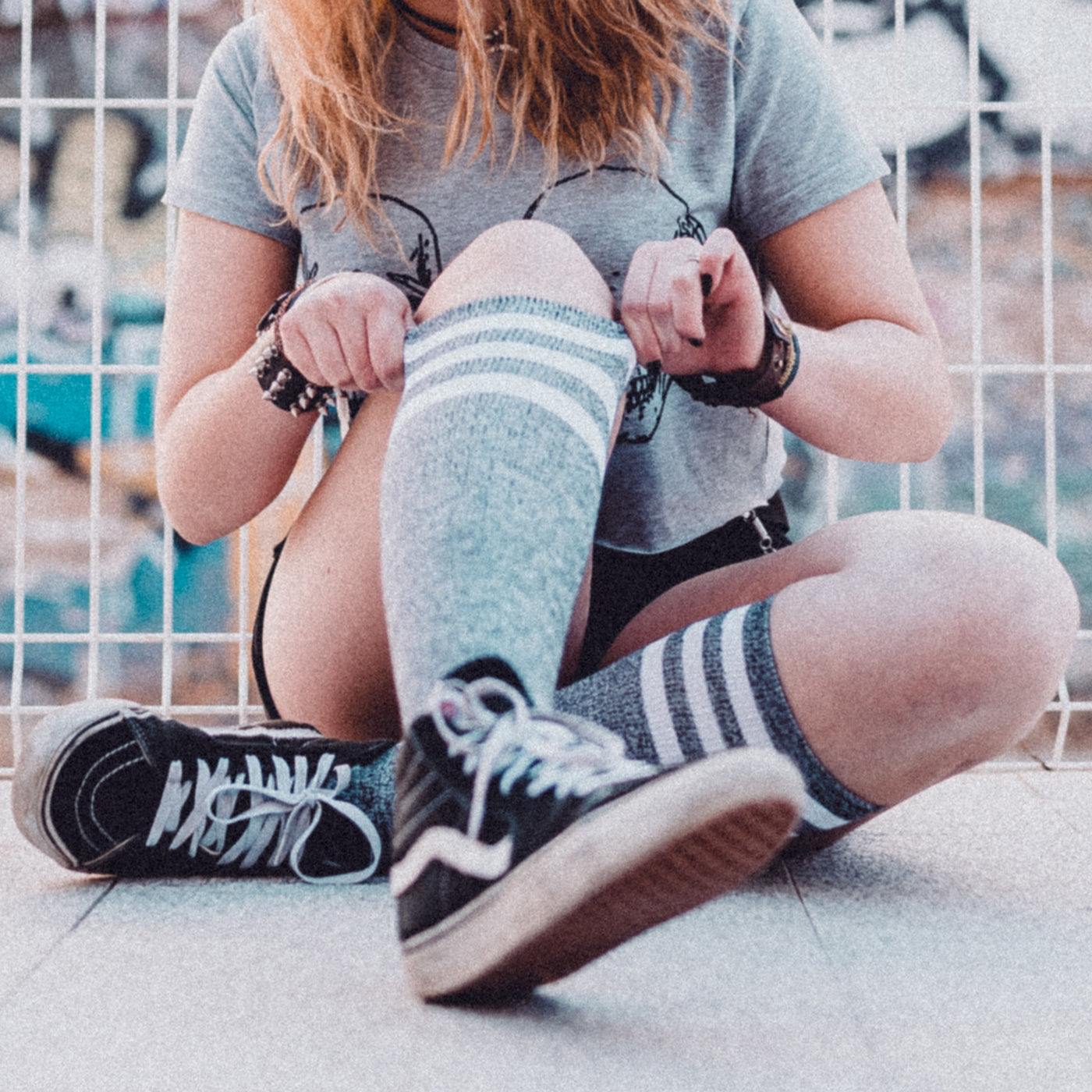 Woman with skater style with legs in the foreground wearing cool gray knee high socks american socks 